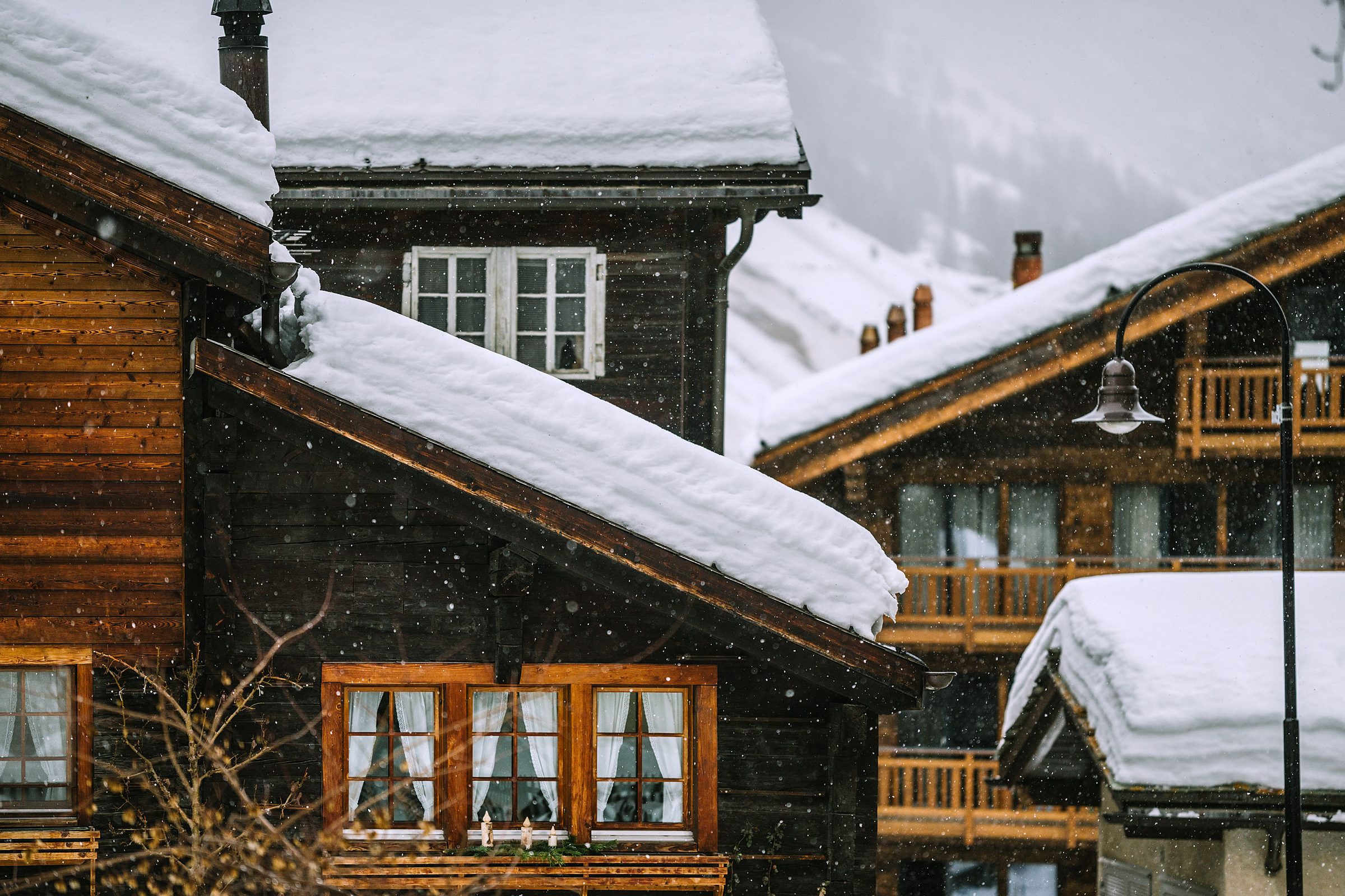 Snow-covered chalets in falling snow in Megeve